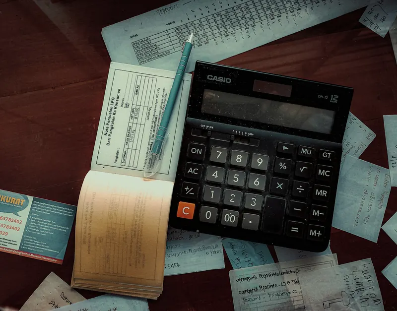 A calculator and tax papers on a desk