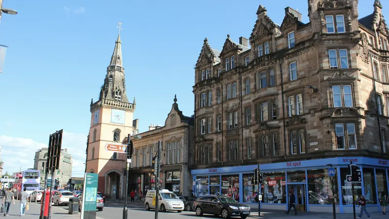 Sandstone buildings and shops on a sunny Glasgow street
