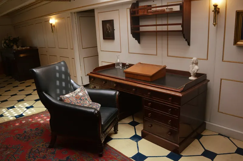 A traditional private office with a leather armchair and a wooden desk